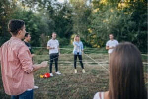 Junge Erwachsene stehen im Kreis und halten eine Schnur, die ein Netz zwischen den Personen bildet.