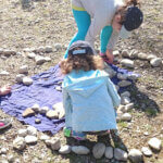 Kinder legen Steinen zu einer langen Schlange.