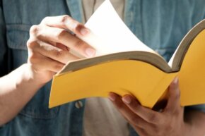 eine Person blättert in einem Buch